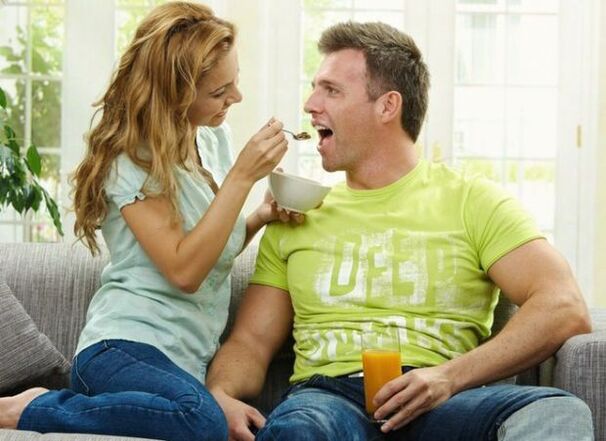 seorang wanita memberi makan seorang lelaki dengan produk untuk meningkatkan potensi